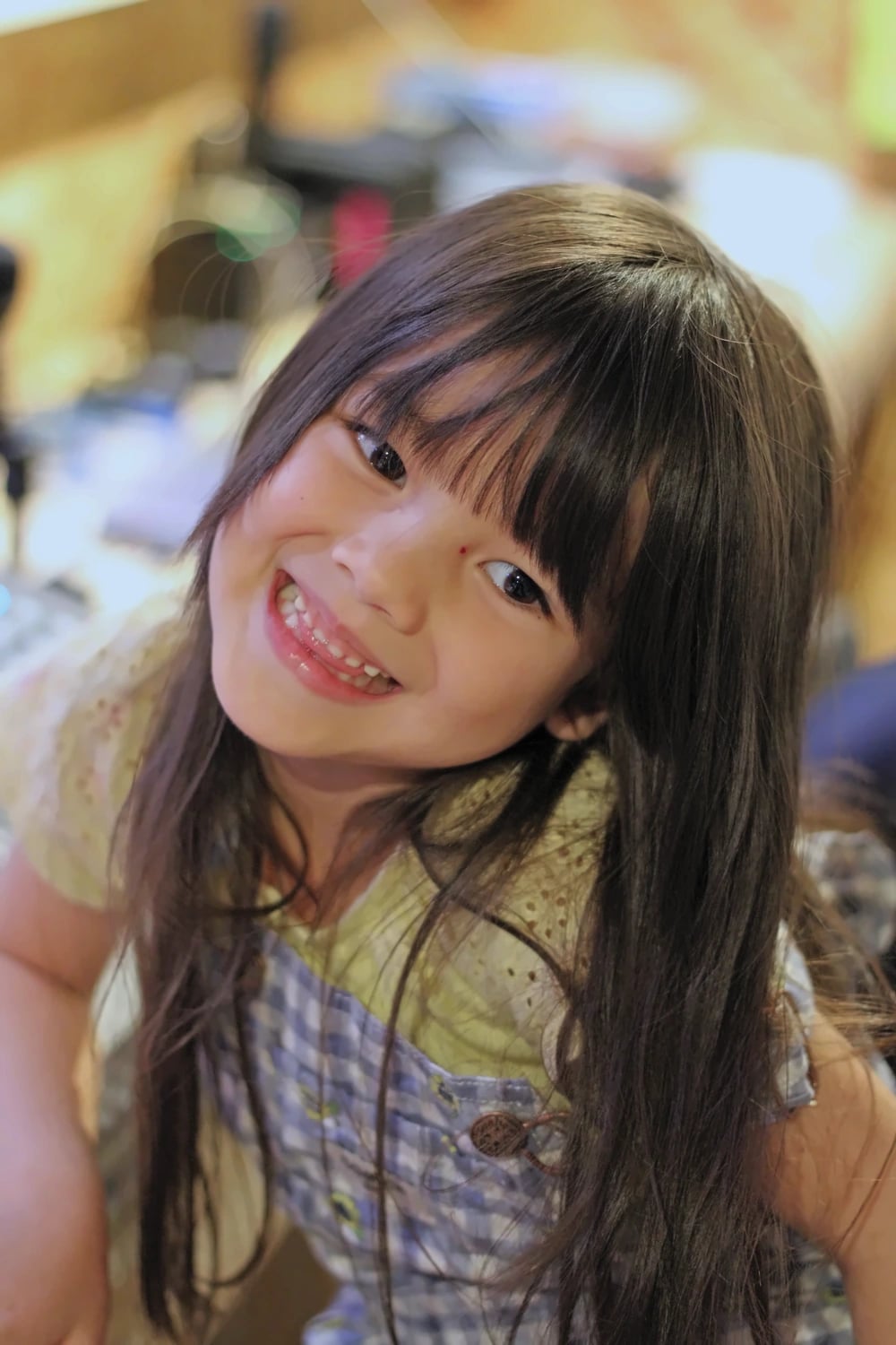 A young girl smiles toward the camera.